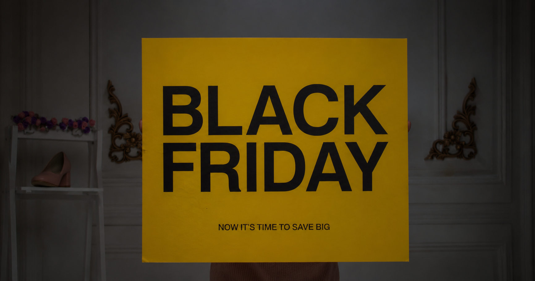 Black Friday sale sign displaying a bold '50% off' discount in yellow and black, promoting savings and discounts.