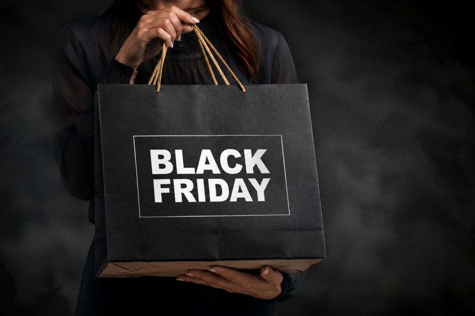 Shopper holding a Black Friday shopping bag against a dark background, representing Black Friday marketing campaigns, ecommerce promotions, and seasonal sales strategy.