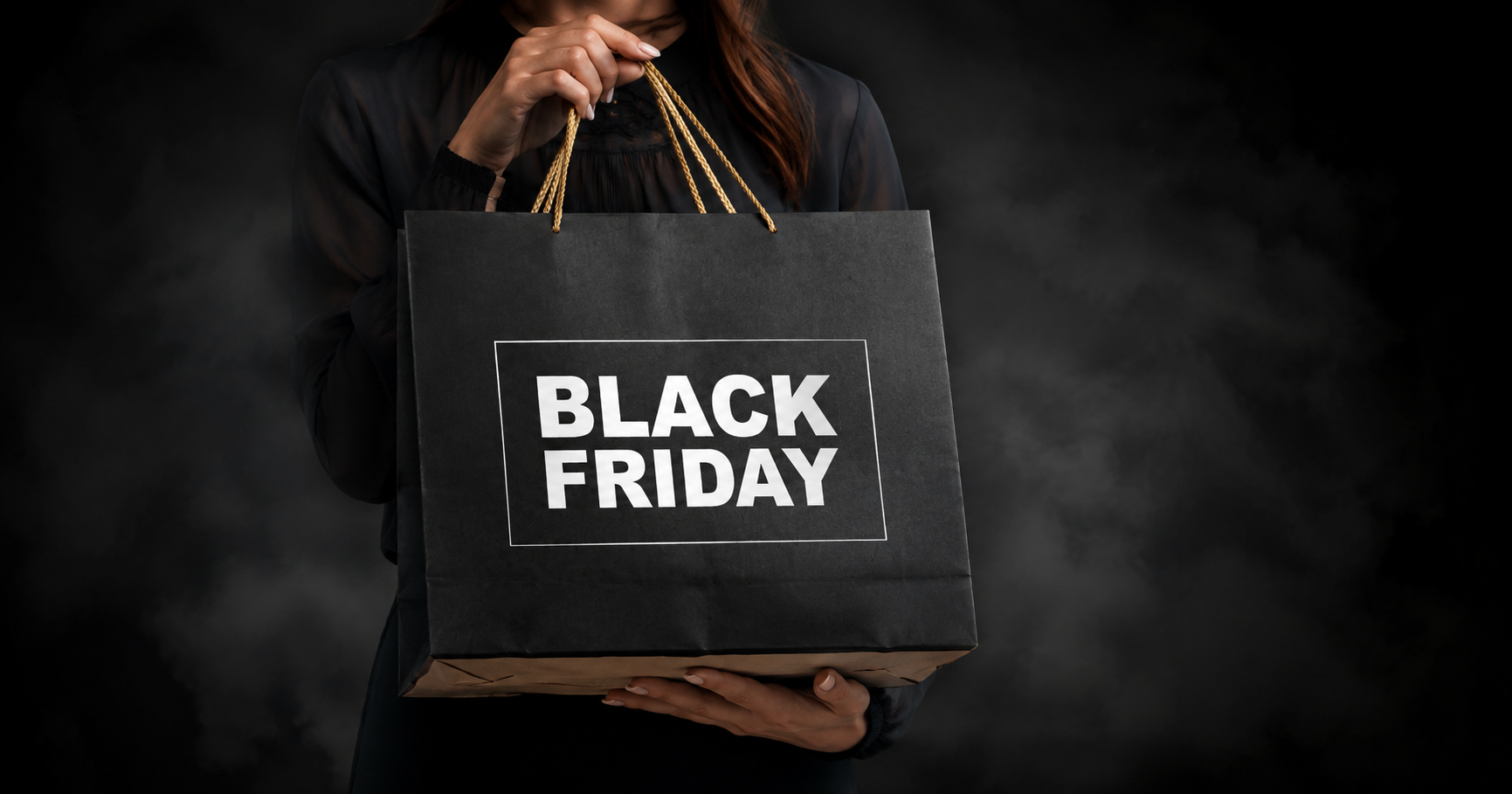 Shopper holding a Black Friday shopping bag against a dark background, representing Black Friday marketing campaigns, ecommerce promotions, and seasonal sales strategy.